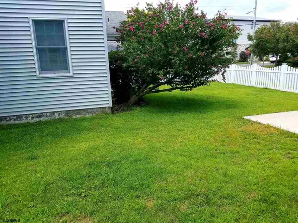 a front view of a house with garden and trees