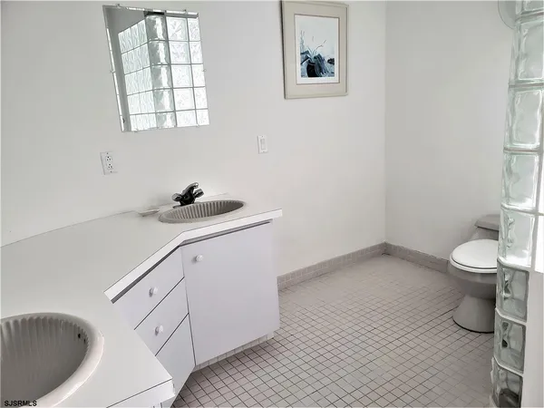 a bathroom with a sink toilet and a window