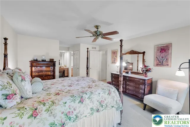 a bedroom with a bed dresser and a flat screen tv