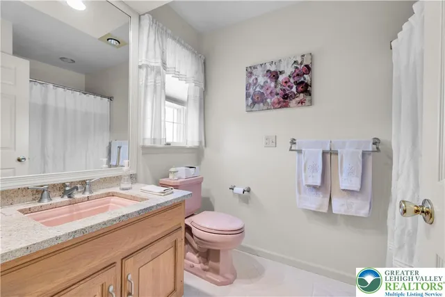 a bathroom with a granite countertop sink a toilet and a mirror