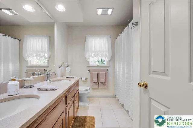 a en suite bathroom with a double vanity sink a mirror and a shower
