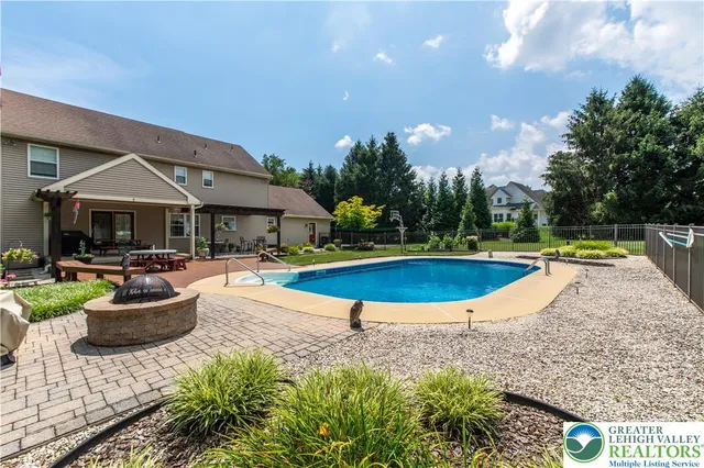 a view of a house with swimming pool and sitting area