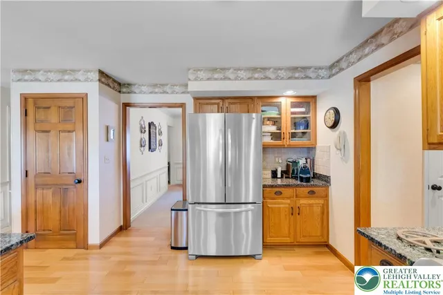 a kitchen with stainless steel appliances granite countertop a refrigerator and a stove top oven