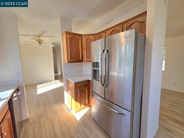 a kitchen with stainless steel appliances a refrigerator and a wooden floor