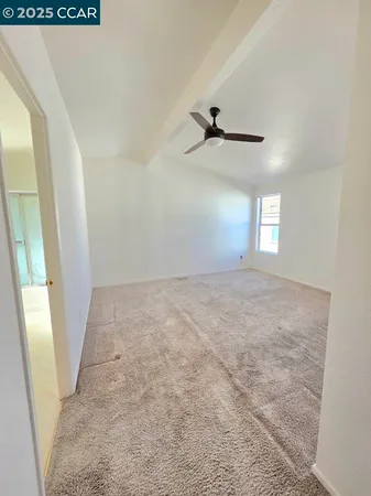 a view of an empty room and a ceiling fan