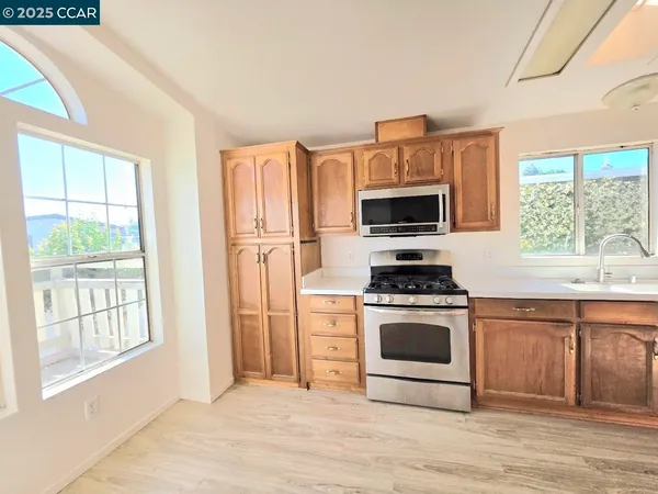 a kitchen with stainless steel appliances a stove a sink and a microwave