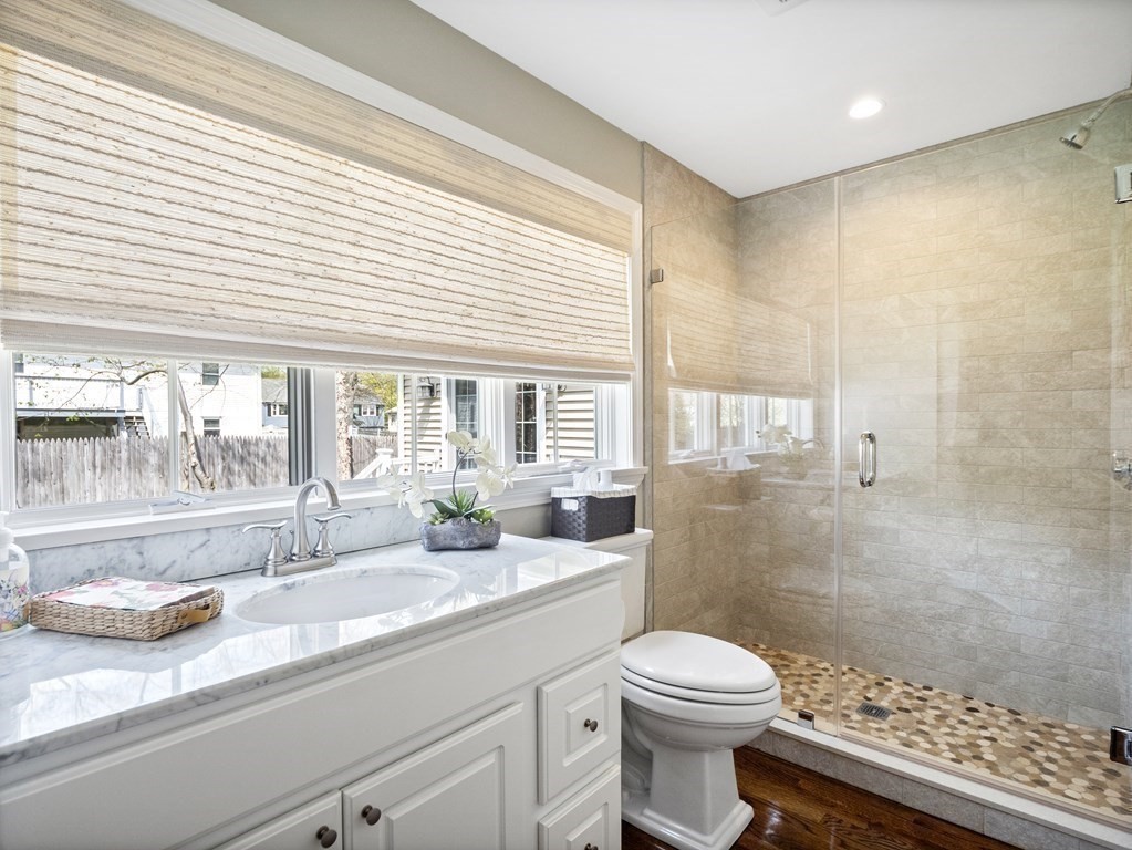 43 Windsor Road Stoneham, MA 02180 - Photo 18 of 42 a bathroom with a granite countertop sink a toilet a mirror and shower