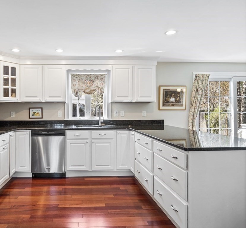 43 Windsor Road Stoneham, MA 02180 - Photo 32 of 42 a kitchen with granite countertop white cabinets and wooden floor