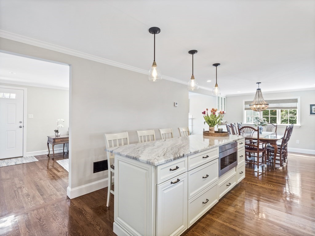43 Windsor Road Stoneham, MA 02180 - Photo 7 of 42 a kitchen with granite countertop a table chairs stove and wooden floor