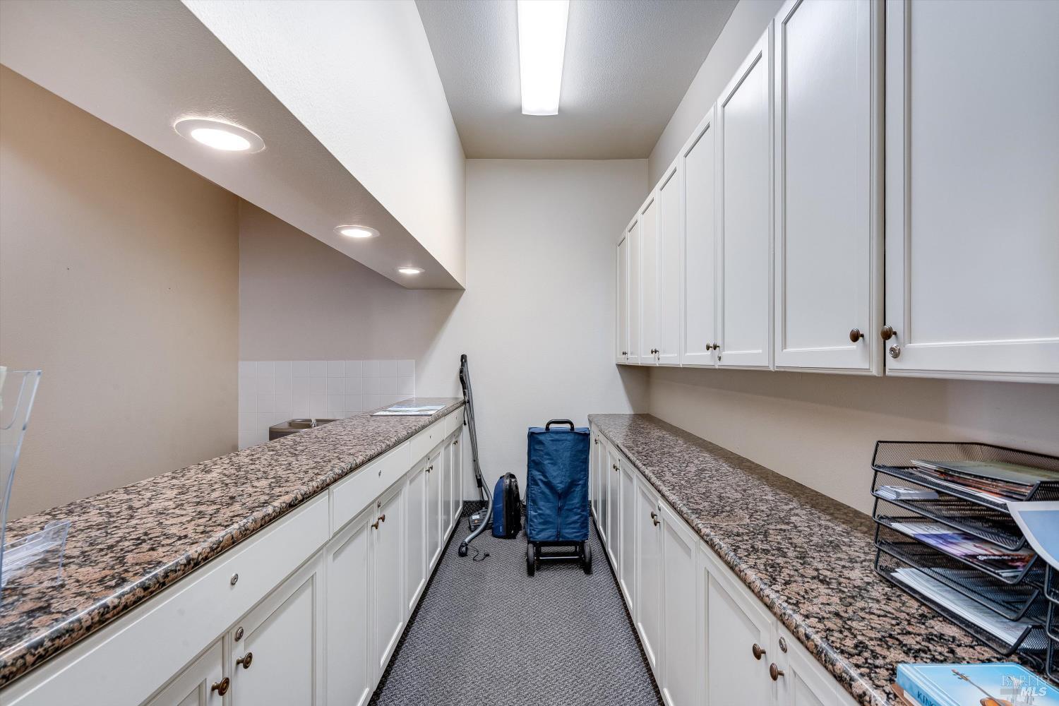 1105 University Avenue Healdsburg, CA 95448 - Photo 14 of 29 a kitchen with granite countertop white cabinets and stainless steel appliances