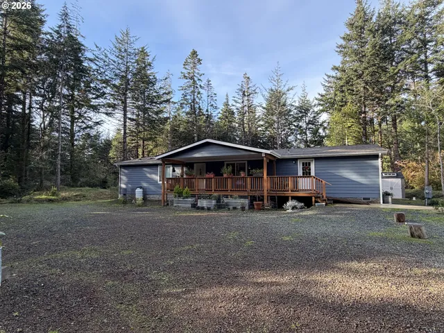 a view of a house with large trees and parked area