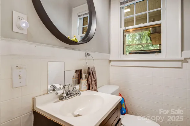 a bathroom with a sink a toilet and a mirror