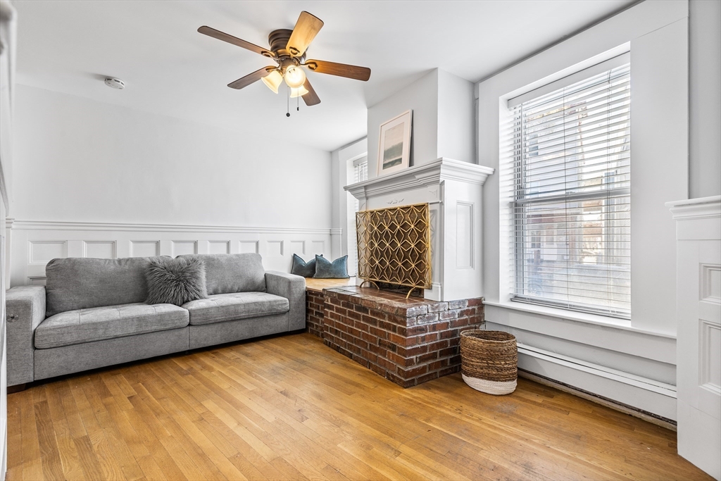 a living room with furniture ceiling fan and a window