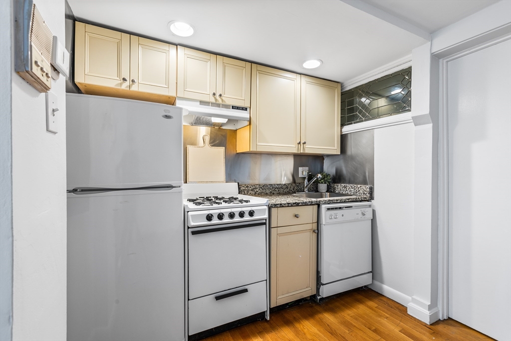 86 Savin Hill Avenue, Unit 1 Boston, MA 02125 - Photo 5 of 17 a kitchen with stainless steel appliances granite countertop a refrigerator sink and cabinets