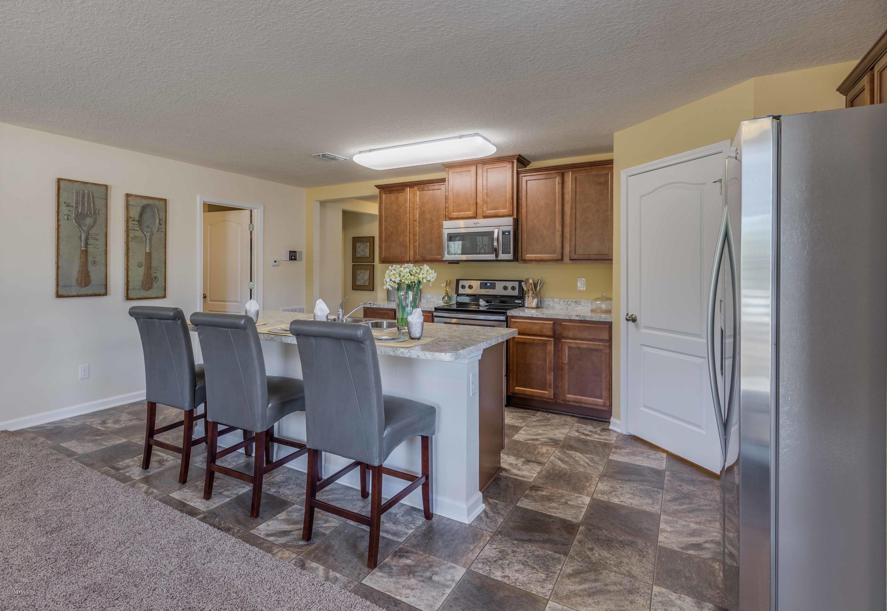 3820 Great Falls Loop Middleburg, FL 32068 - Photo 16 of 36 a kitchen with a refrigerator a table and chairs