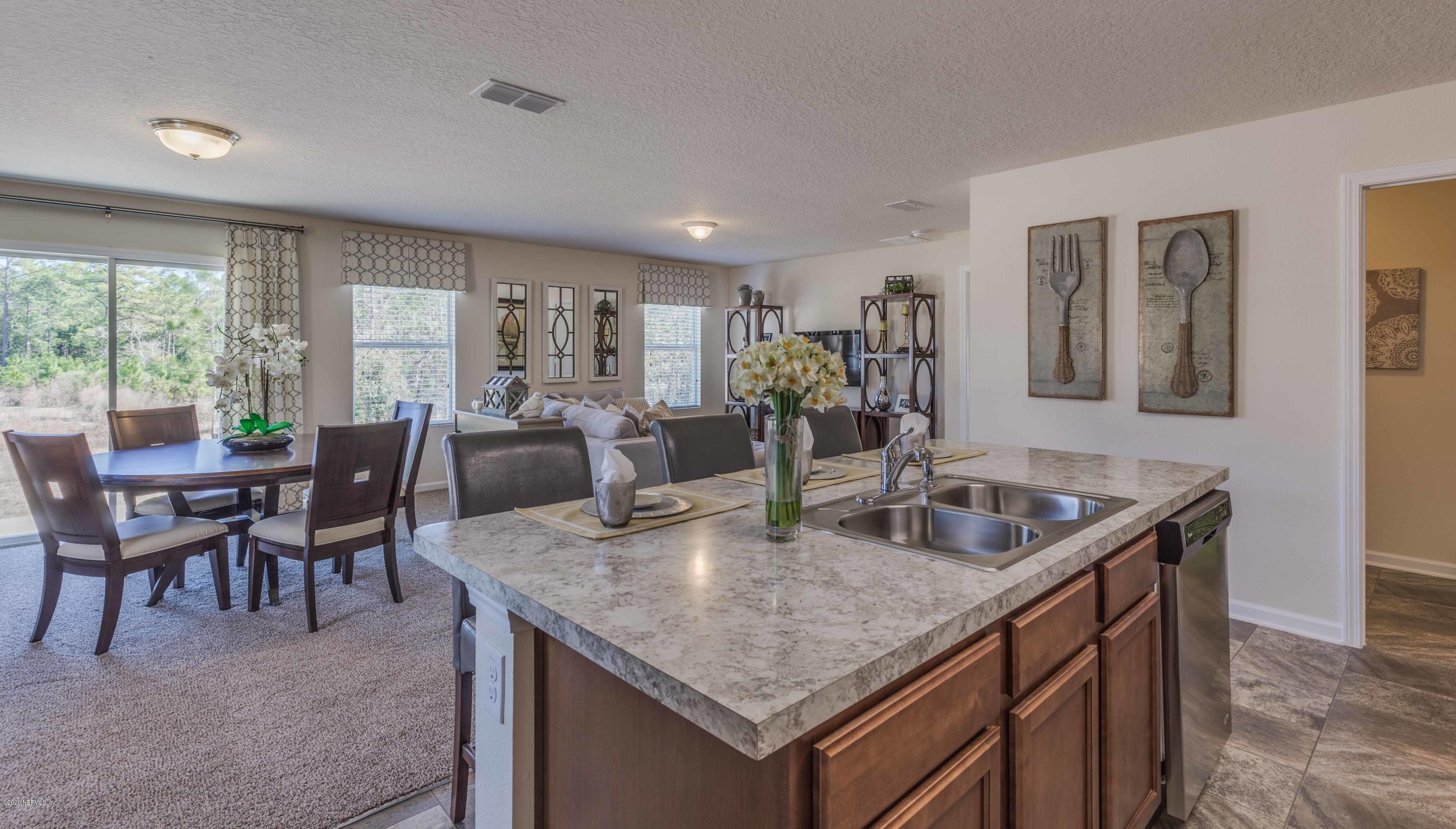 3820 Great Falls Loop Middleburg, FL 32068 - Photo 17 of 36 a kitchen with granite countertop kitchen island stainless steel appliances a table and chairs