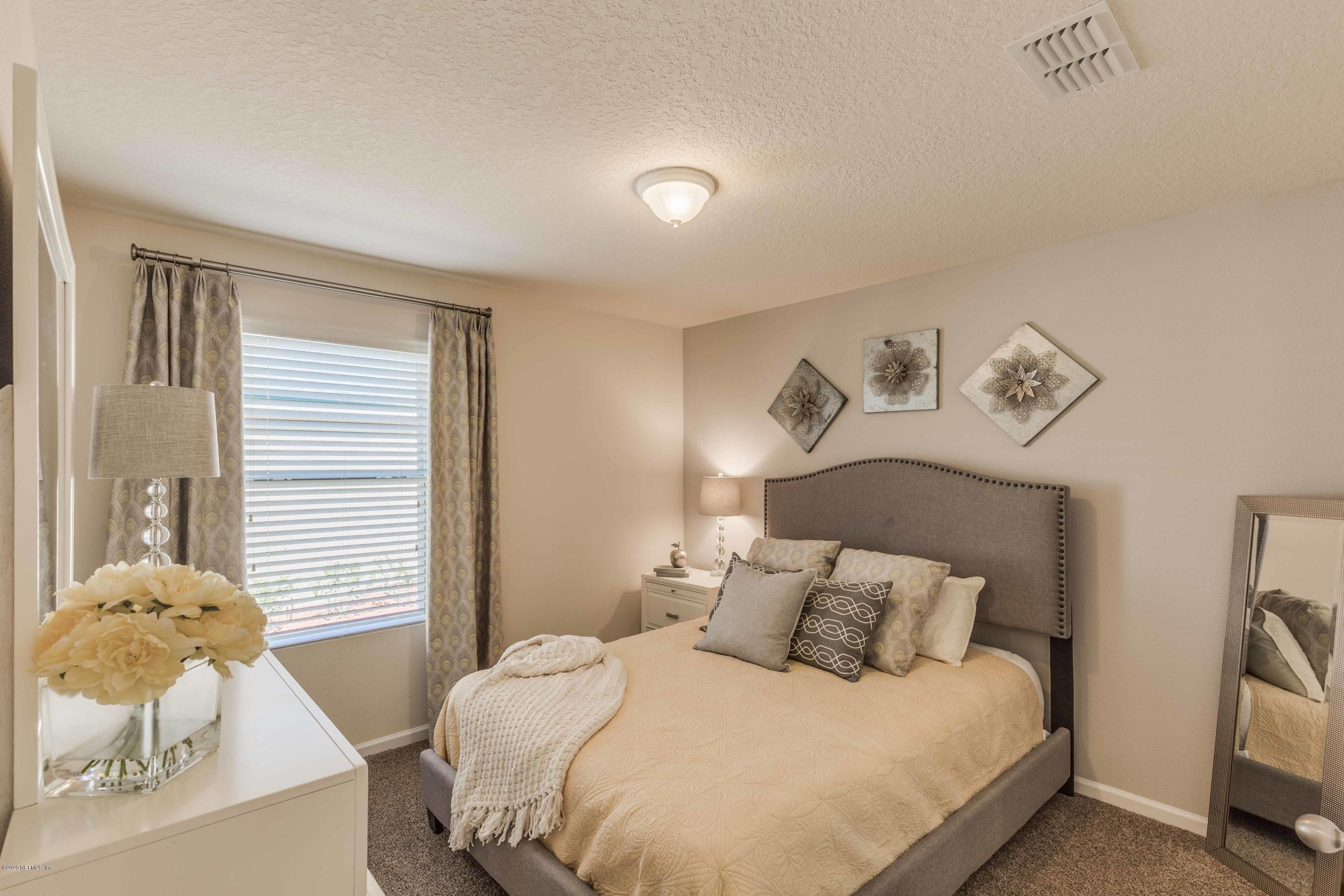3820 Great Falls Loop Middleburg, FL 32068 - Photo 21 of 36 a bedroom with a bed and a chandelier