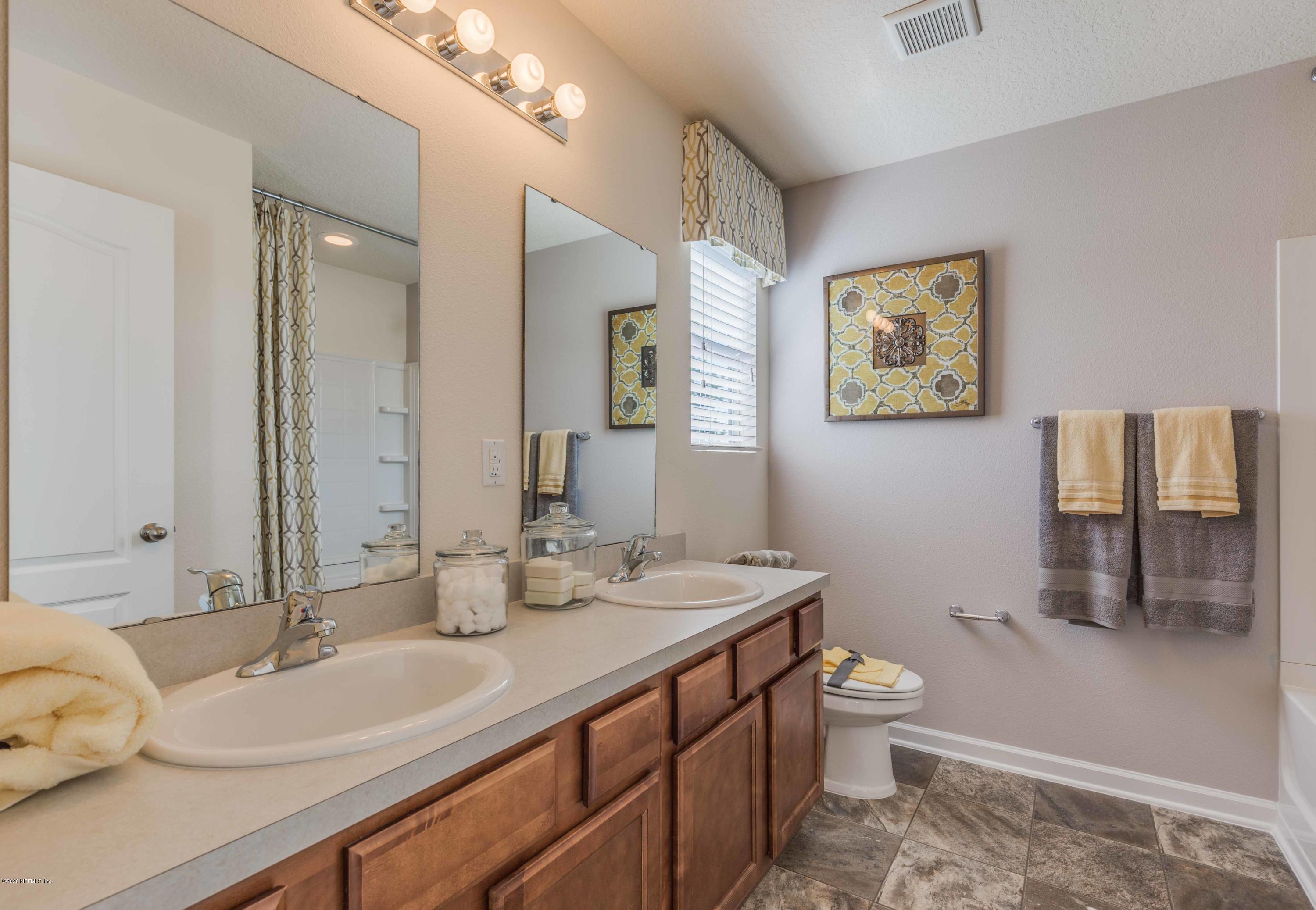 3820 Great Falls Loop Middleburg, FL 32068 - Photo 24 of 36 a bathroom with a double vanity sink toilet and a mirror
