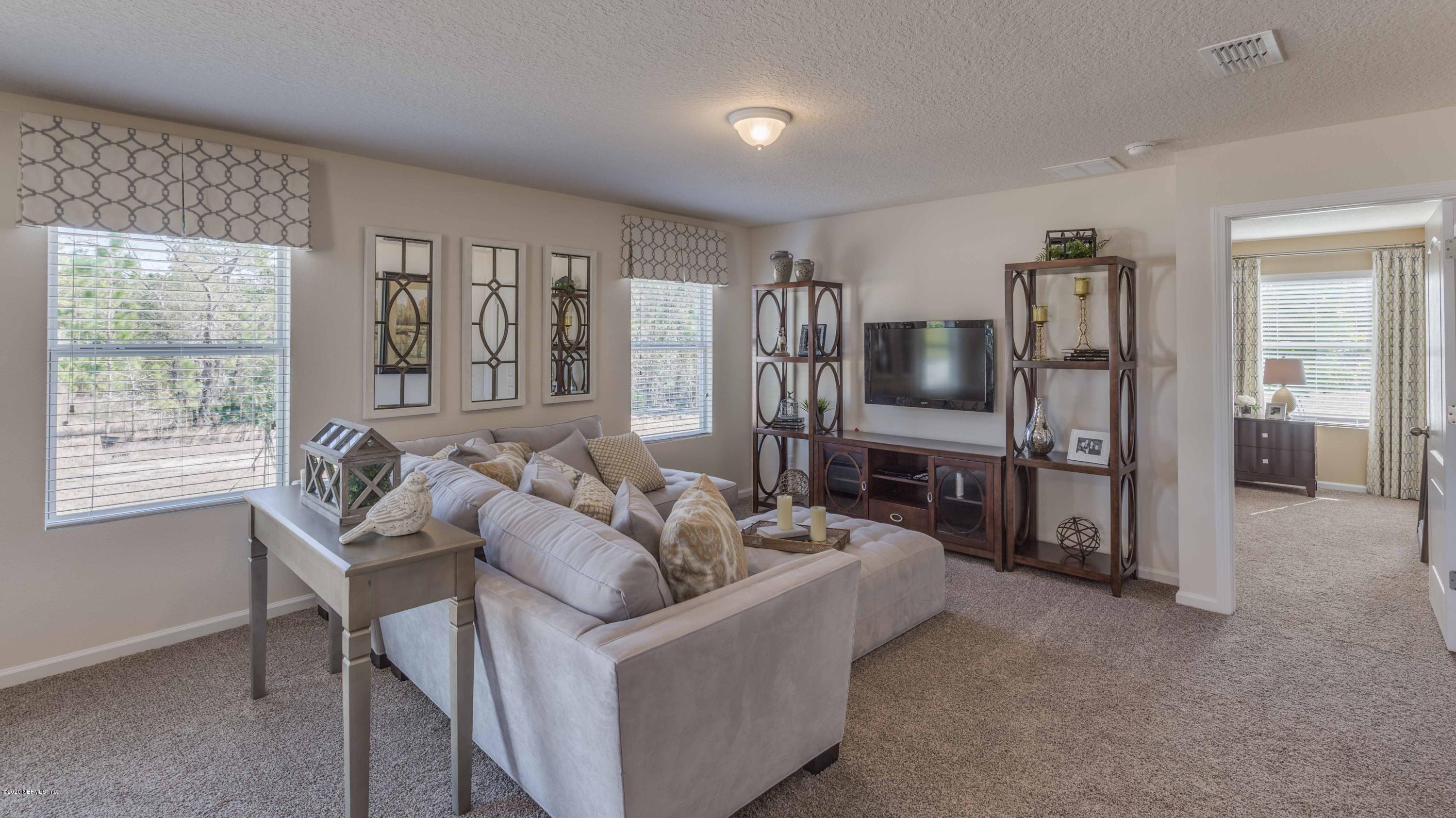 3820 Great Falls Loop Middleburg, FL 32068 - Photo 8 of 36 a living room with furniture a large window and a flat screen tv