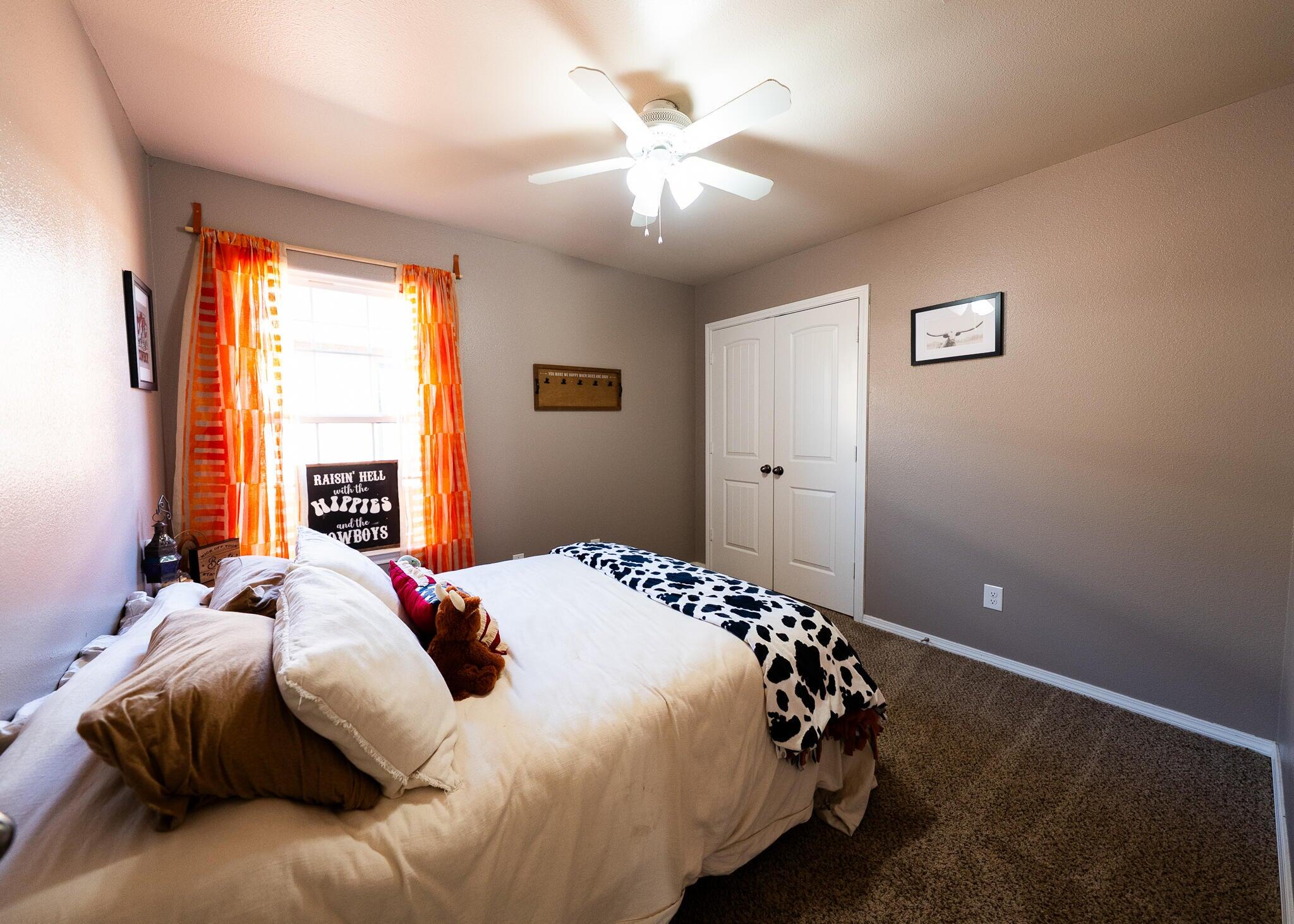9104 Quincy Avenue Lubbock, TX 79424 - Photo 13 of 15 a bedroom with a bed and a chandelier
