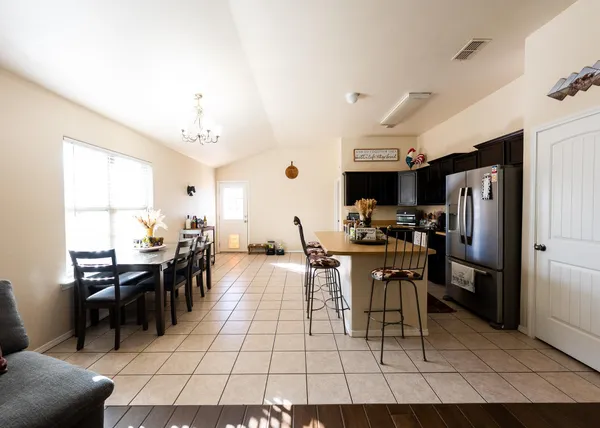 a kitchen with stainless steel appliances kitchen island granite countertop a sink and a refrigerator