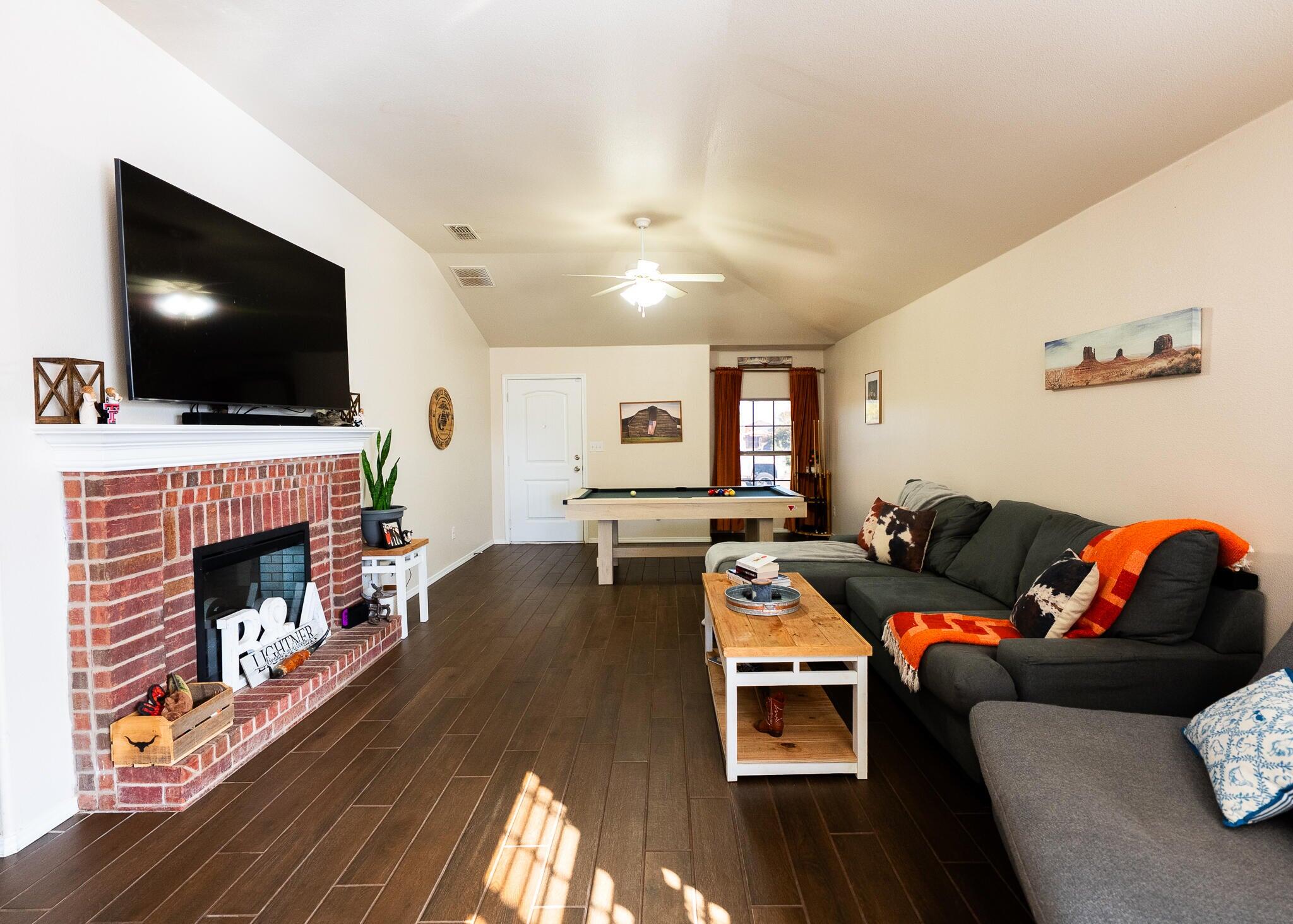 9104 Quincy Avenue Lubbock, TX 79424 - Photo 5 of 15 a living room with furniture a flat screen tv and a fireplace