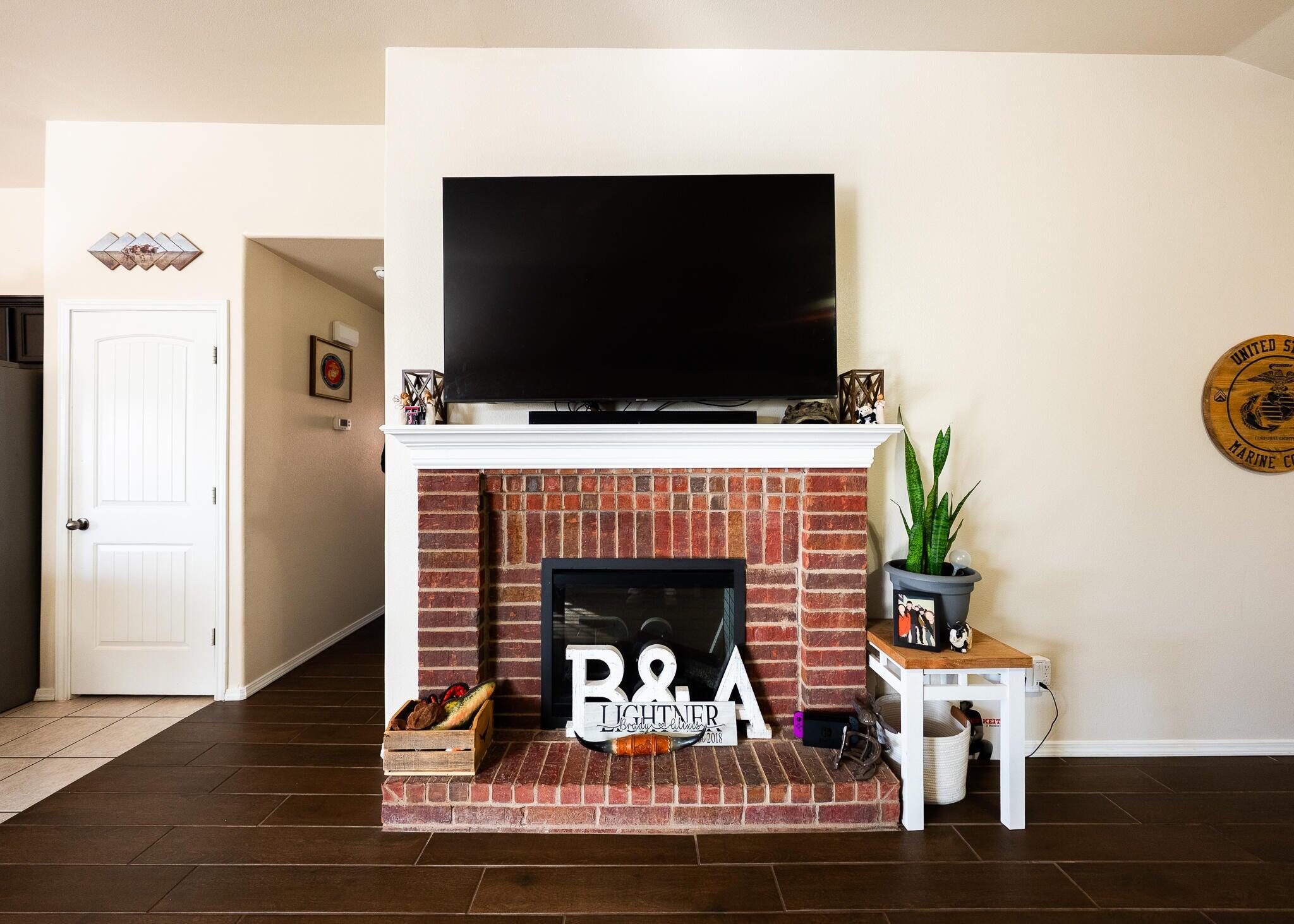 9104 Quincy Avenue Lubbock, TX 79424 - Photo 6 of 15 a living room with furniture a flat screen tv and a fireplace