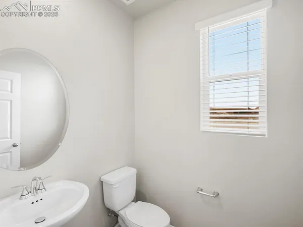 a bathroom with a toilet a sink and mirror