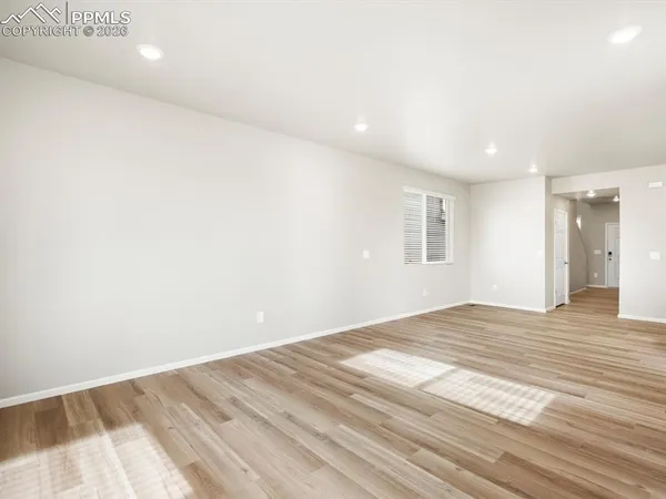 a view of empty room with wooden floor