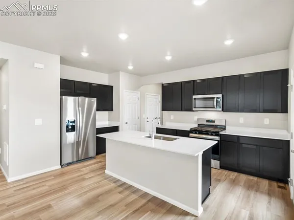 a kitchen with stainless steel appliances a refrigerator stove microwave and cabinets