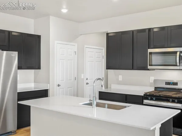 a kitchen with stainless steel appliances a stove microwave and refrigerator