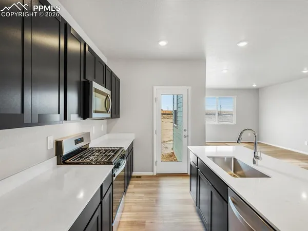 a kitchen with stainless steel appliances granite countertop a sink and stove