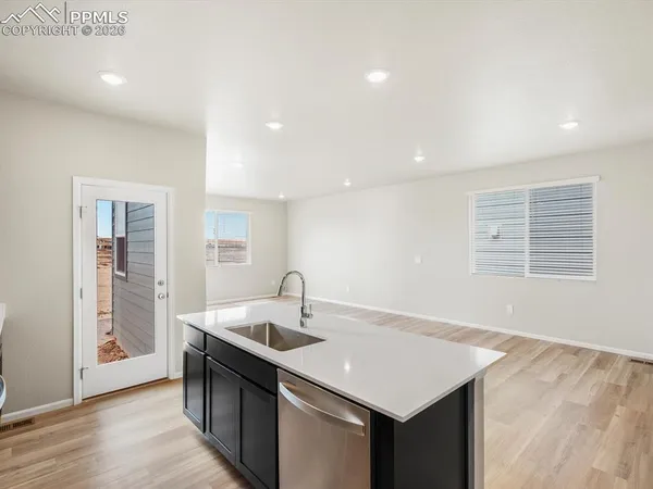 a kitchen with a sink a counter space and wooden floor