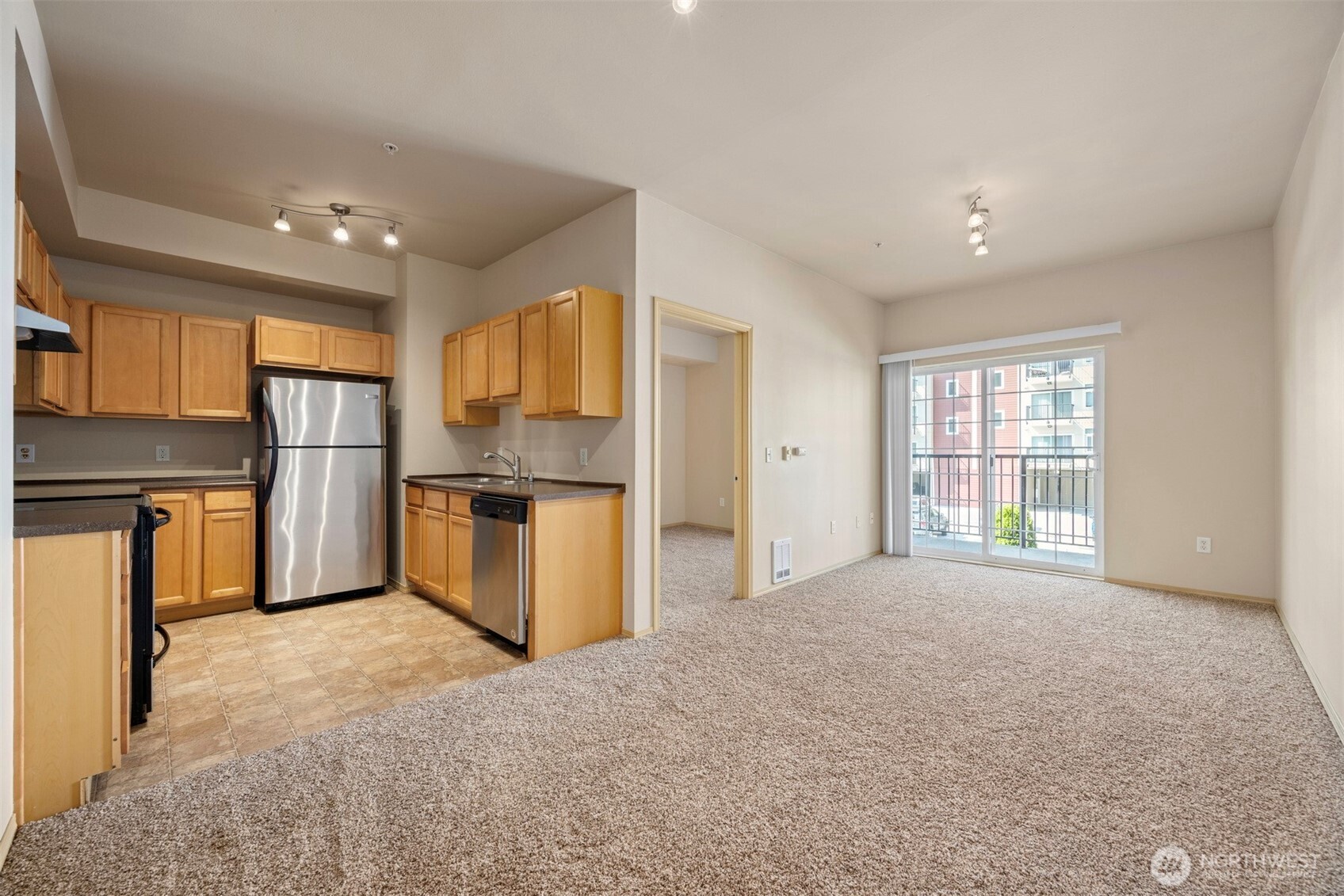 1031 North State Street, Unit 107 Bellingham, WA 98225 - Photo 12 of 33 a kitchen with stainless steel appliances granite countertop a refrigerator a sink dishwasher a oven and a dining table with wooden cabinet