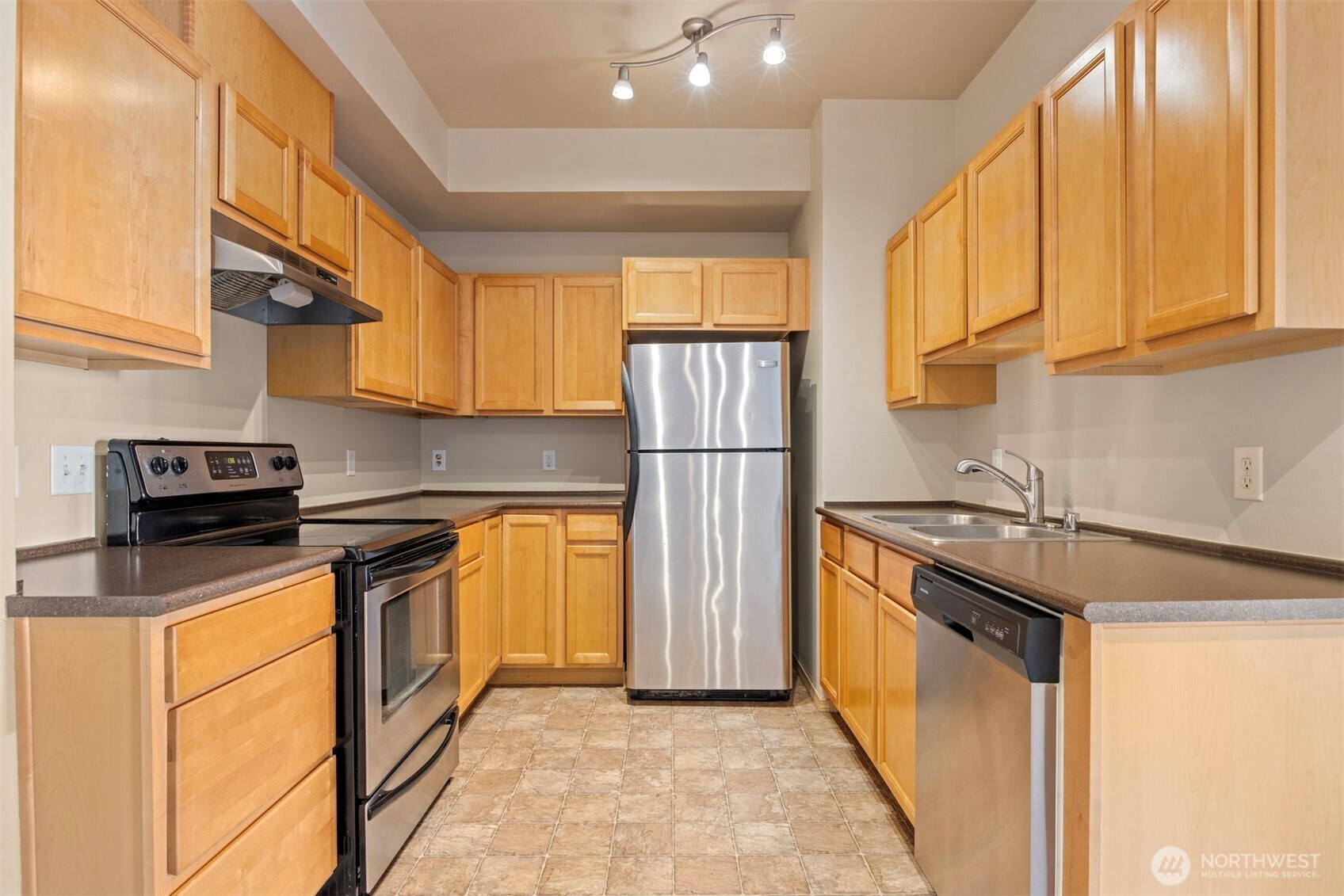 1031 North State Street, Unit 107 Bellingham, WA 98225 - Photo 14 of 33 a kitchen with stainless steel appliances granite countertop a refrigerator a stove and a sink