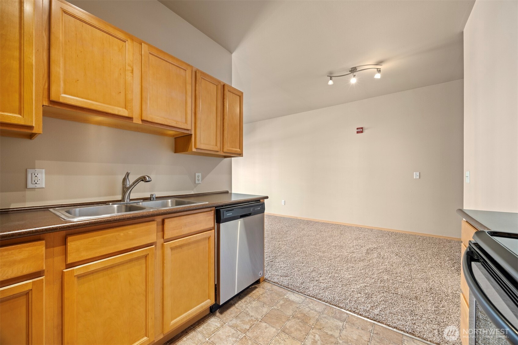1031 North State Street, Unit 107 Bellingham, WA 98225 - Photo 15 of 33 a kitchen with granite countertop a sink a stove and cabinets