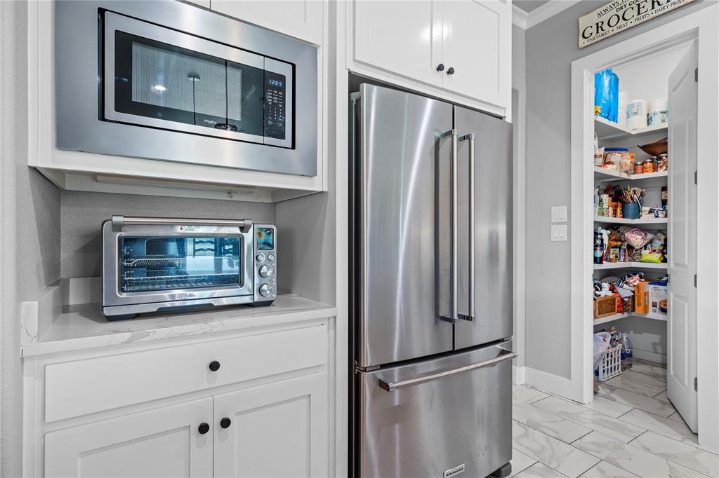 1024 Henry Way Springtown, TX 76082 - Photo 10 of 29 Stainless steel appliances, including a built-in microwave and French door refrigerator, complement white cabinetry