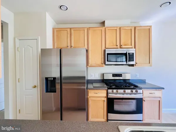 a kitchen with stainless steel appliances granite countertop a refrigerator stove and microwave
