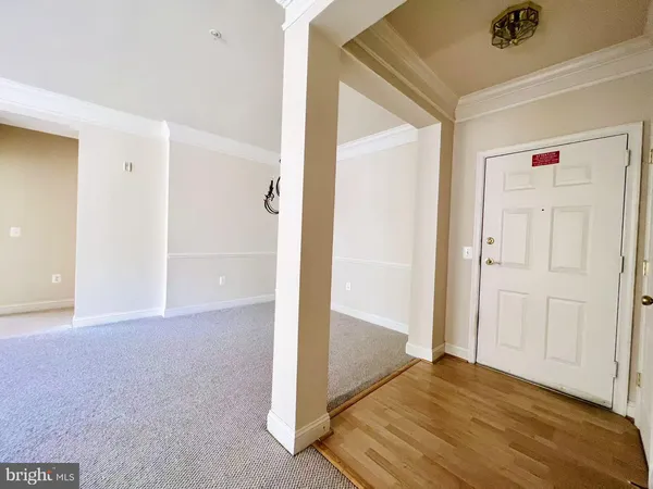 a view of a livingroom with wooden floor and a bathroom