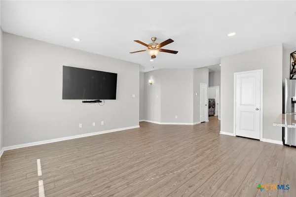 en empty room with ceiling fan and window