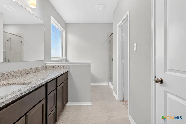 a bathroom with a granite countertop sink and a mirror