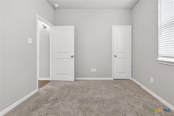 an empty room with windows and closet