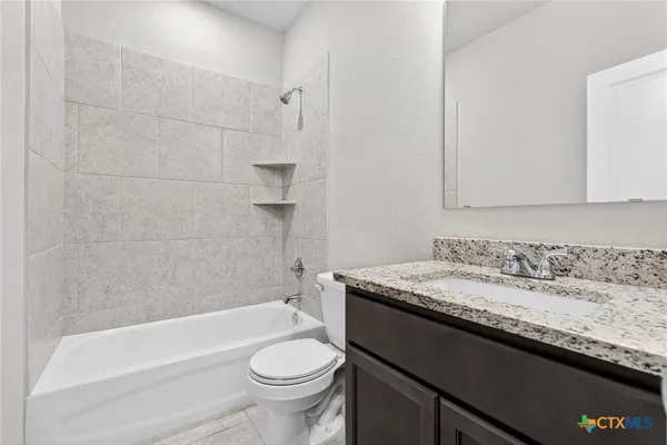 a bathroom with a granite countertop sink a toilet and bathtub