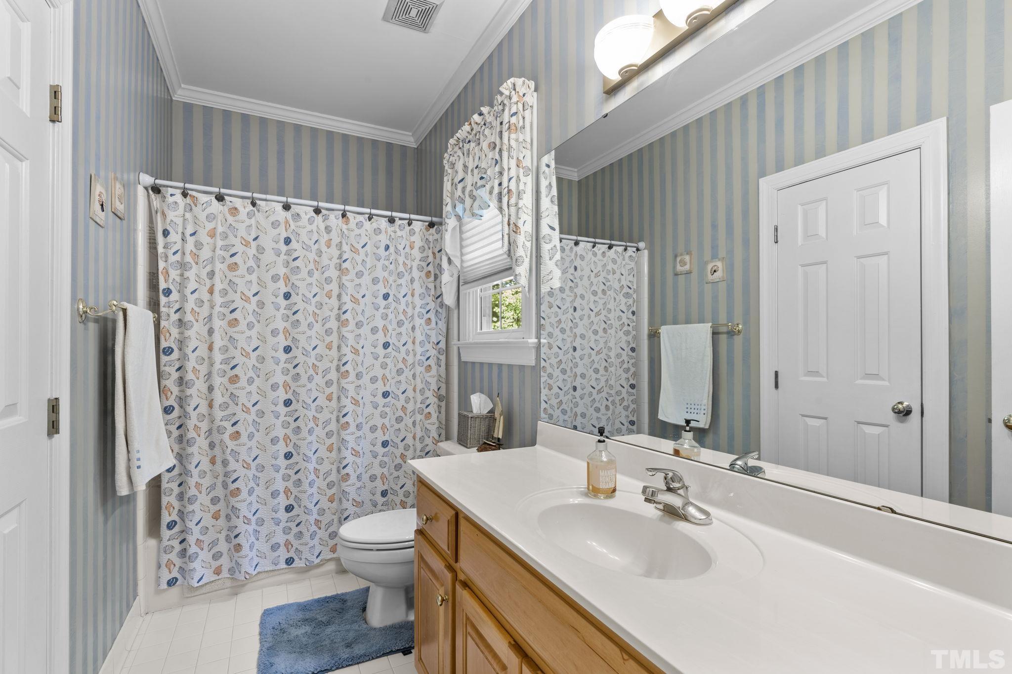 7705 Tylerton Drive Raleigh, NC 27613 - Photo 12 of 35 a bathroom with a sink a toilet and shower curtain