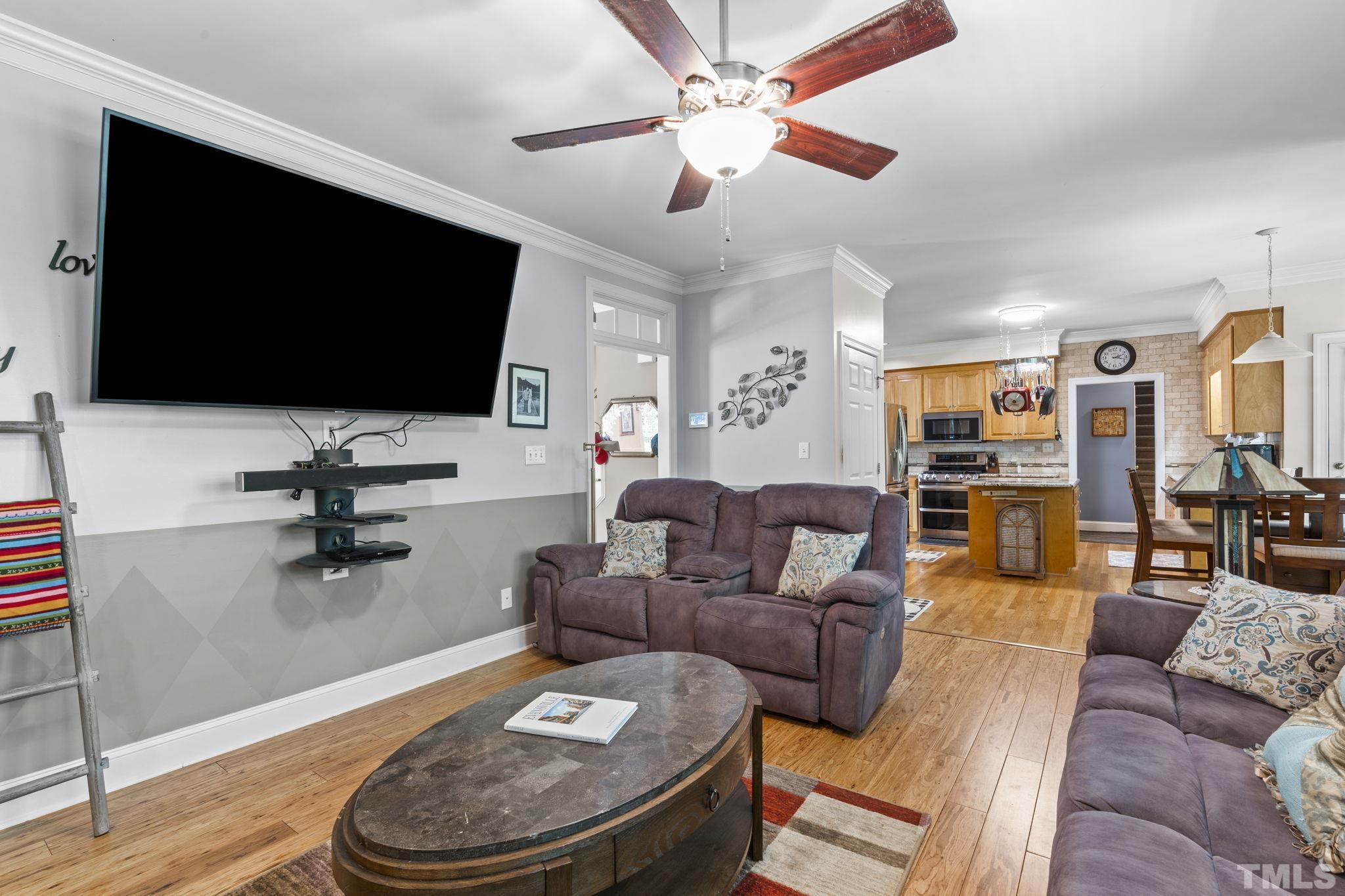 7705 Tylerton Drive Raleigh, NC 27613 - Photo 7 of 35 a living room with furniture and a flat screen tv
