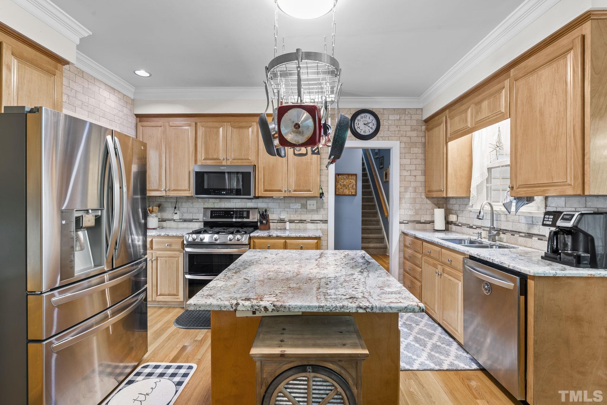 7705 Tylerton Drive Raleigh, NC 27613 - Photo 10 of 35 a kitchen with stainless steel appliances granite countertop a stove refrigerator sink and microwave