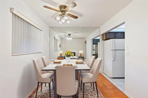 a dining room with furniture a chandelier and wooden floor