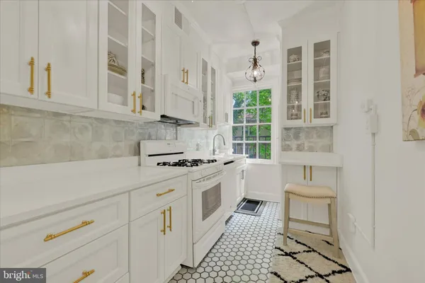 a kitchen with white cabinets and white appliances