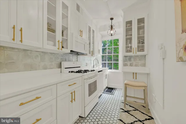 a kitchen with white cabinets and white appliances