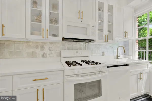 a white stove top oven sitting inside of a kitchen